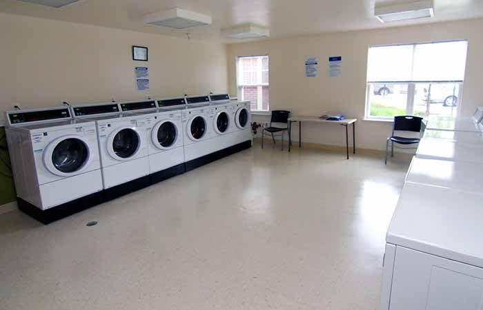 An empty laundromat with a row of washing machines and a clean interior.
