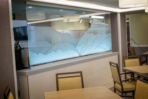 A beautifully designed glass window featuring a mountain motif, adding elegance to the restaurant's interior.