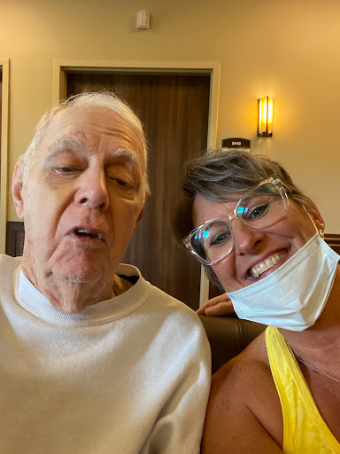 A joyful moment captured in a selfie between a woman and an elderly man.