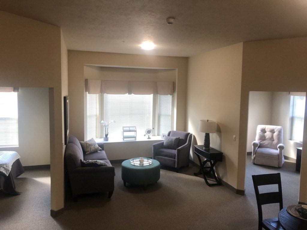 Cozy living room with sofas and a coffee table near a large window.