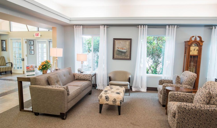 A cozy living room with neutral colors featuring a sofa, armchairs, and a coffee table.