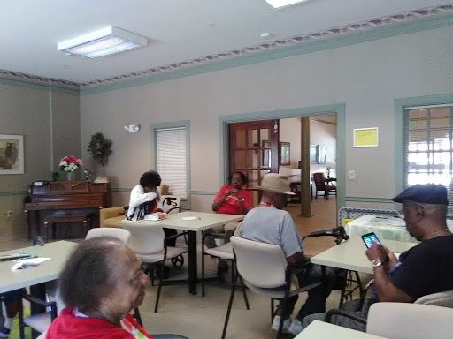 A lively gathering at a community center with people engaged in conversation.