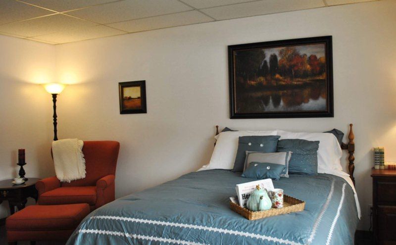 A cozy bedroom with blue bedding, decorative pillows, and wall artwork.