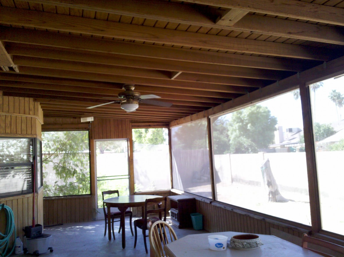 A cozy screened-in porch with a dining area and ceiling fan.