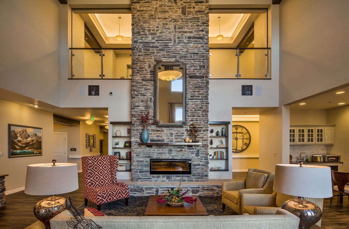 A modern living room with a central stone fireplace, stylish furniture, and decorative elements.