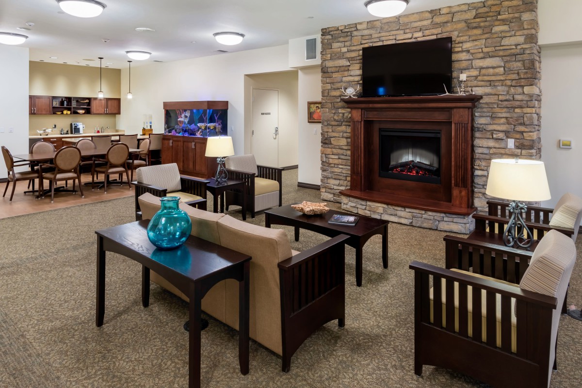 A cozy living room with a stone fireplace and comfortable seating.