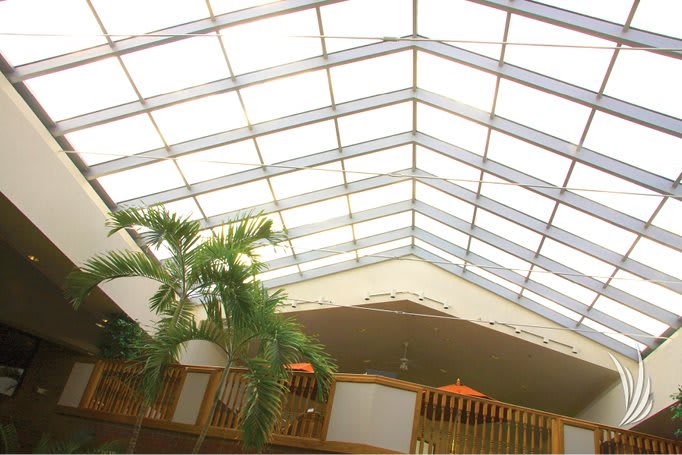 A spacious atrium featuring a large skylight and indoor plants.
