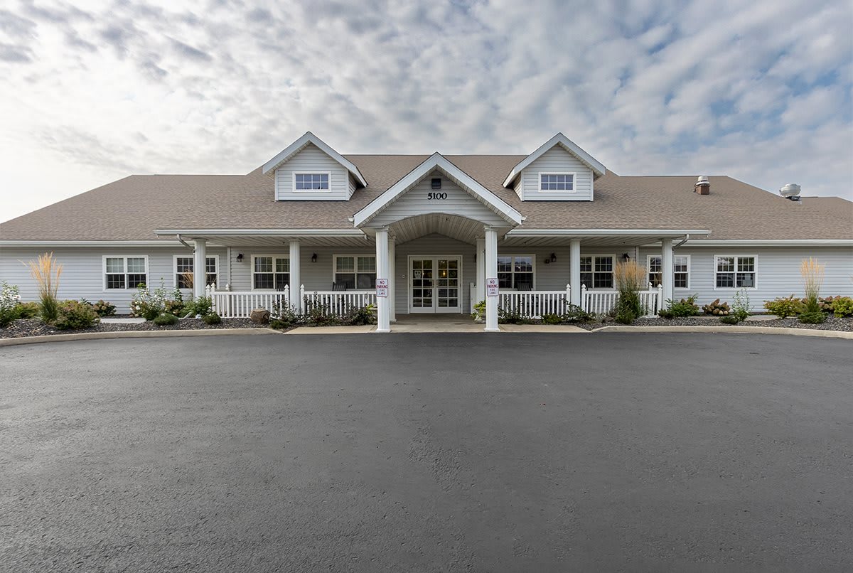 Front view of a large residential building with a paved driveway.