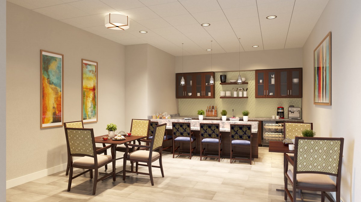 A modern kitchen and dining area featuring a countertop with bar stools and a small dining table.