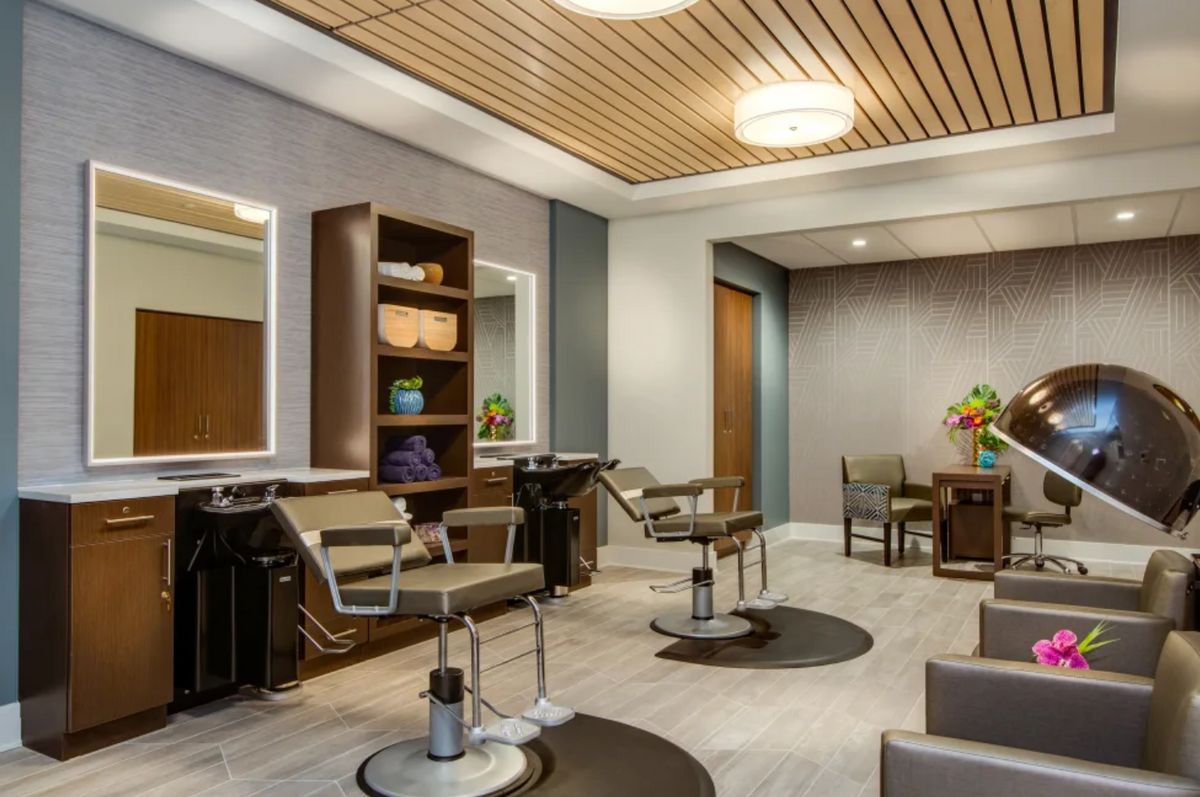 A modern hair salon interior with stylish chairs and mirrors.