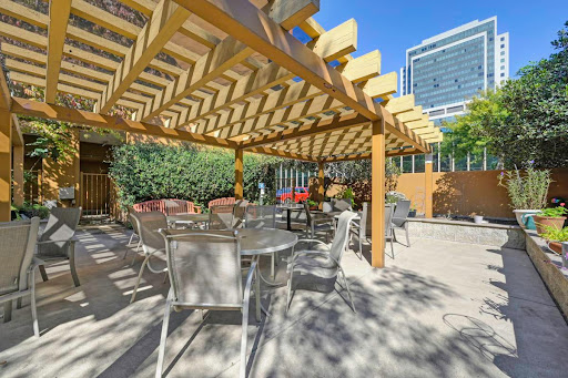 A cozy outdoor seating area shaded by a beautifully designed pergola, perfect for enjoying sunny days.