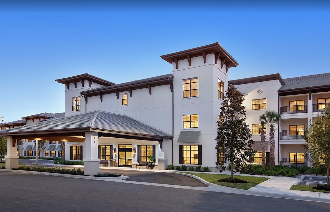 A modern residential building with a welcoming entrance, captured in the evening light.