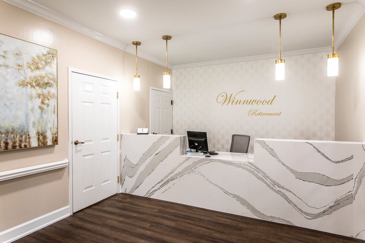A modern reception area with a marble-patterned desk and stylish lighting.