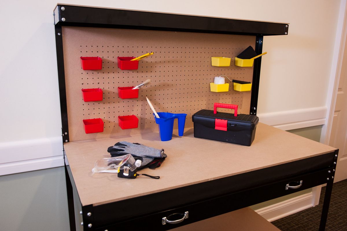 A well-organized workbench with tools and a pegboard for storage.