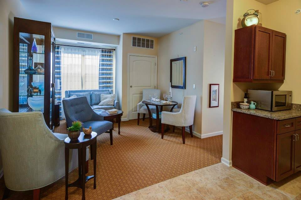 A cozy living room with comfortable seating, a small table, and a large window providing natural light.