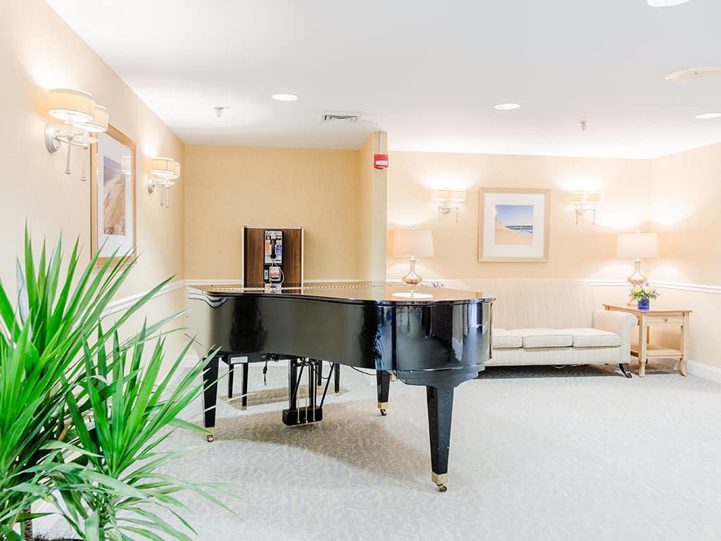 A cozy living room featuring a grand piano with modern decor.