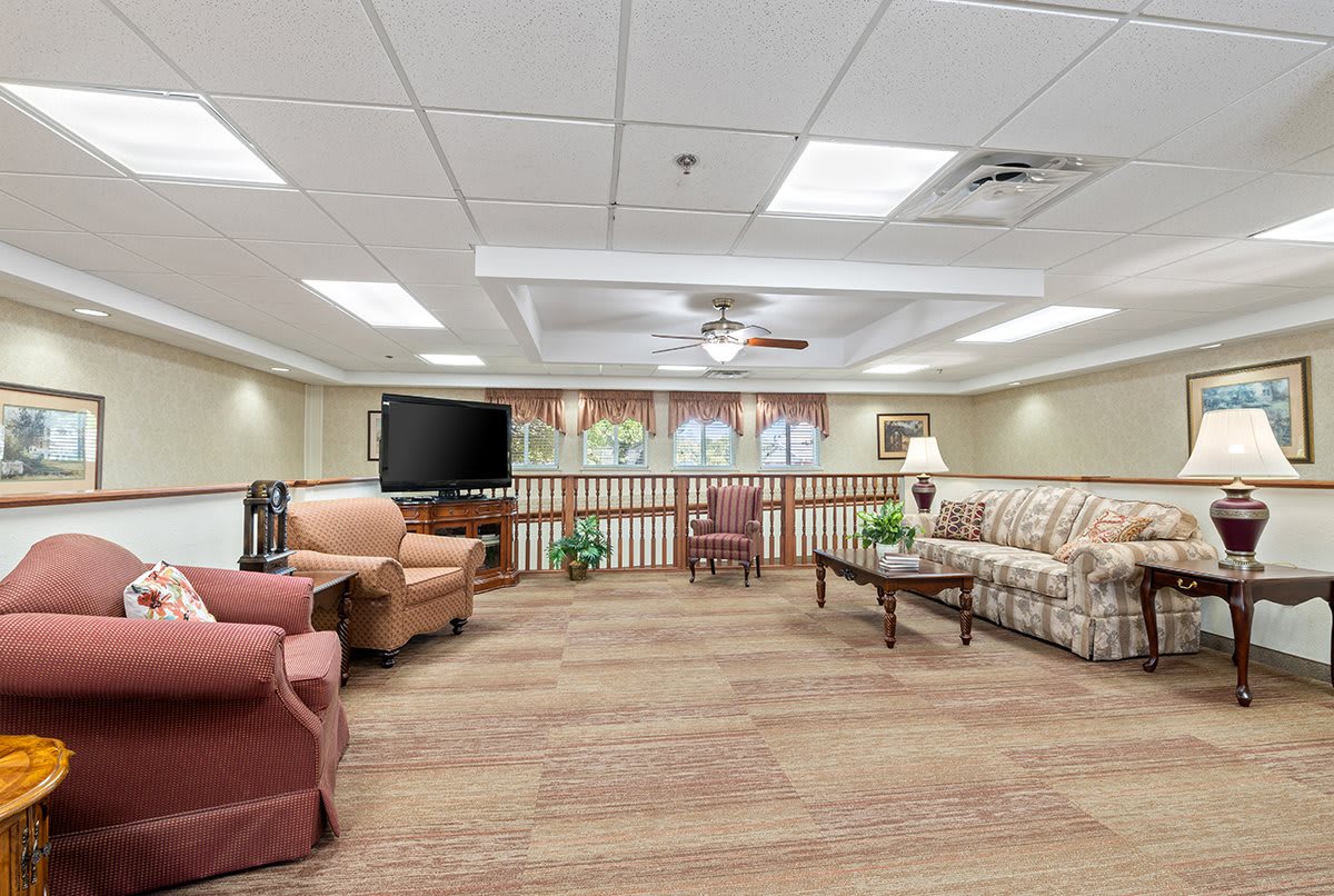 A cozy lounge area with sofas, armchairs, a television, and a coffee table.