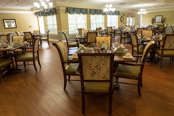 A well-lit dining room with neatly arranged tables and chairs.