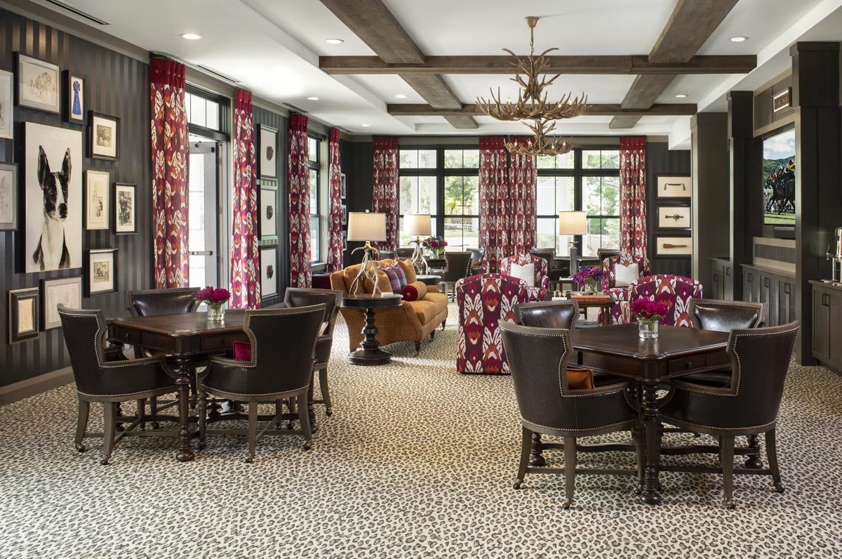 A stylish dining room with patterned curtains, elegant lighting, and comfortable seating arrangements.