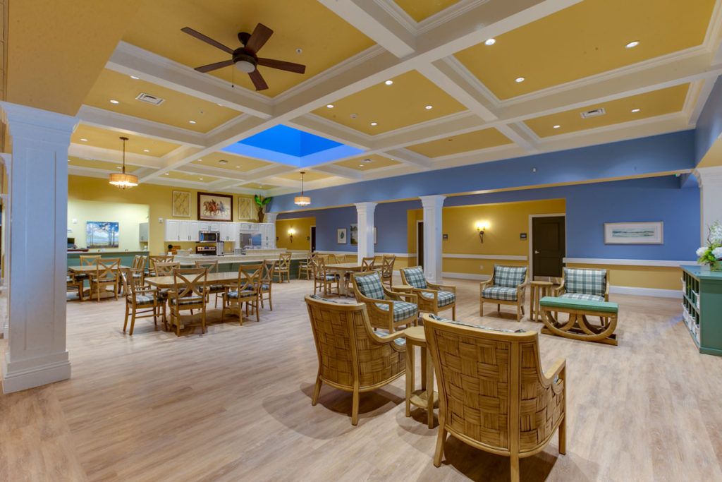 A spacious and well-lit lounge area with comfortable seating and a ceiling fan.