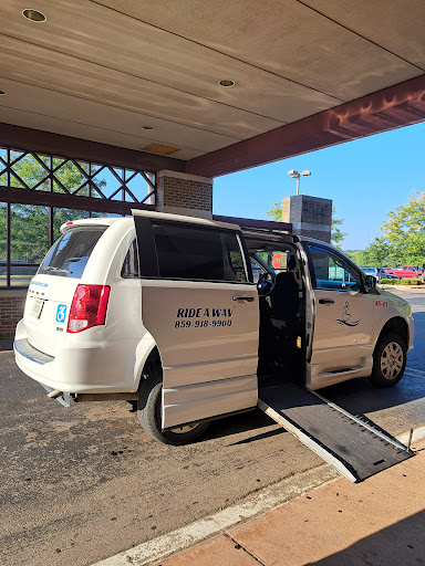 A wheelchair-accessible van parked outside a building with the ramp extended.