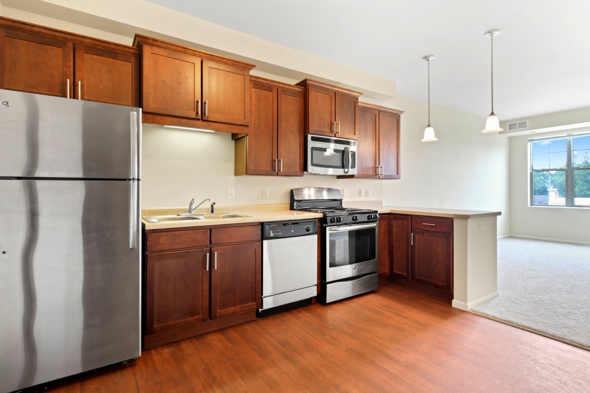 A modern kitchen with wooden cabinets and stainless steel appliances.