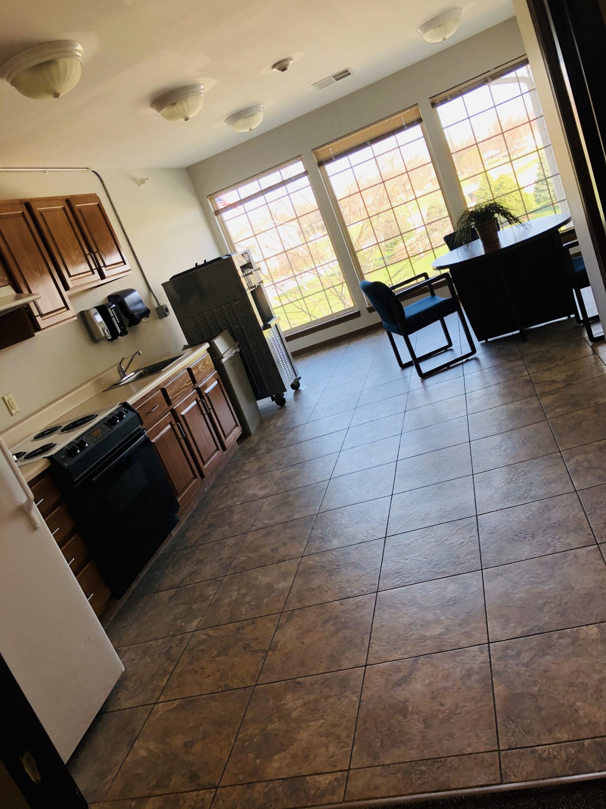 A spacious kitchen with wooden cabinets and a dining area filled with natural light.