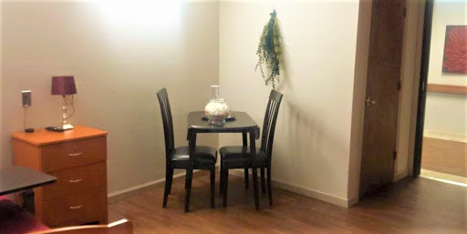 A cozy dining nook featuring a small table and two chairs, complemented by simple decor.