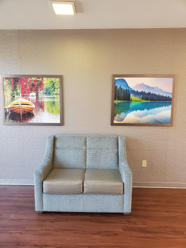 A cozy seating area featuring two colorful paintings on the wall.