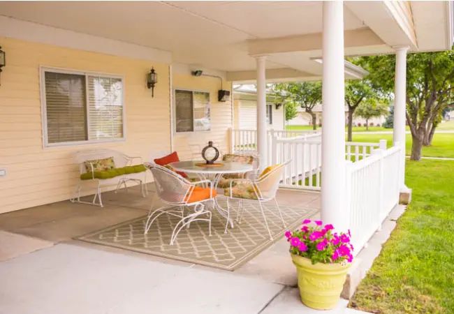 A cozy outdoor porch with comfortable seating and colorful decor.