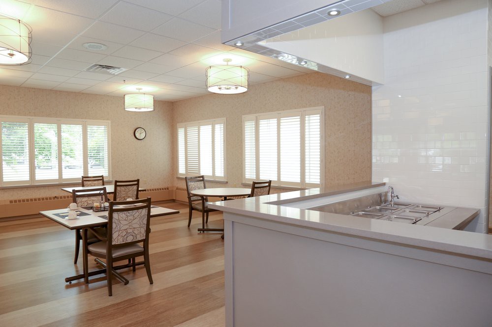 A well-lit dining area with tables and chairs arranged neatly.