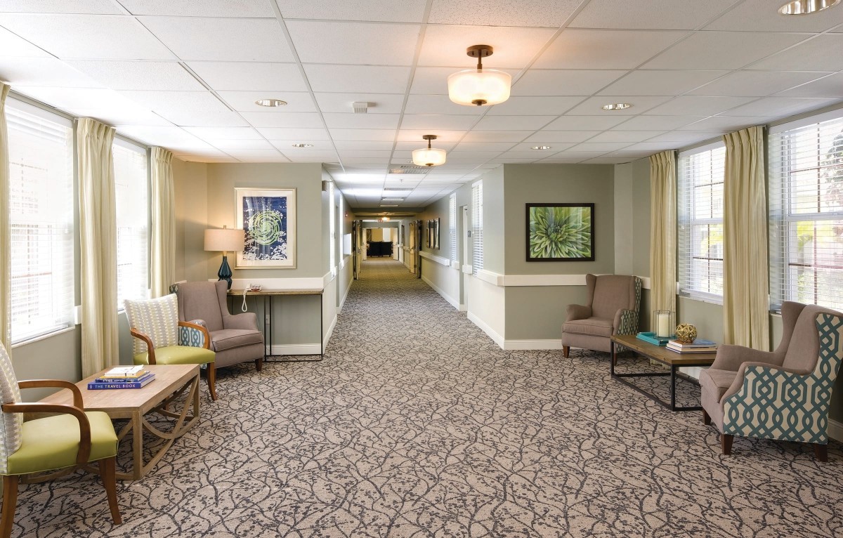 A well-decorated hallway with comfortable seating and framed artworks on the walls.
