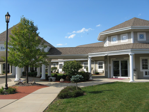 A charming residential building with a welcoming front yard and clear blue skies.