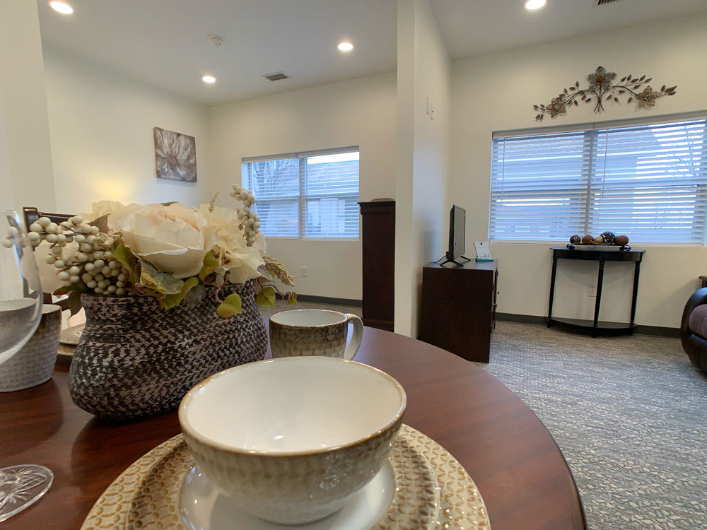A cozy, modern interior featuring a dining table with stylish decor and ample natural light from large windows.