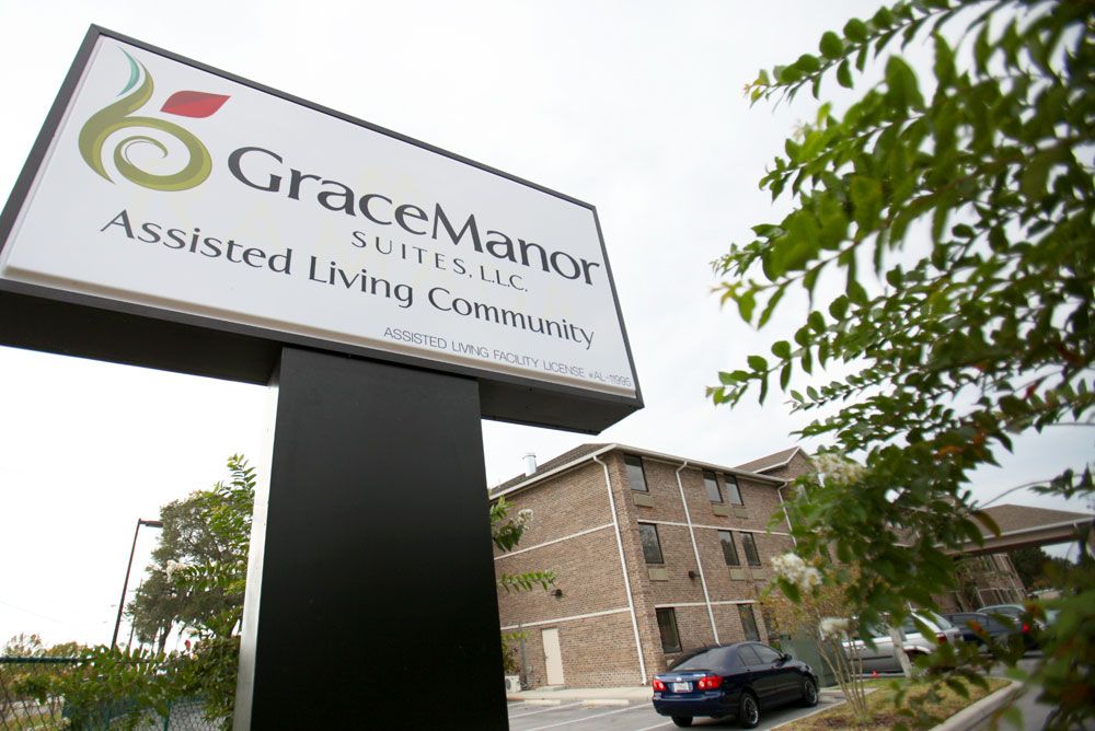 Entrance sign for Grace Manor Assisted Living Community with the building in the background.