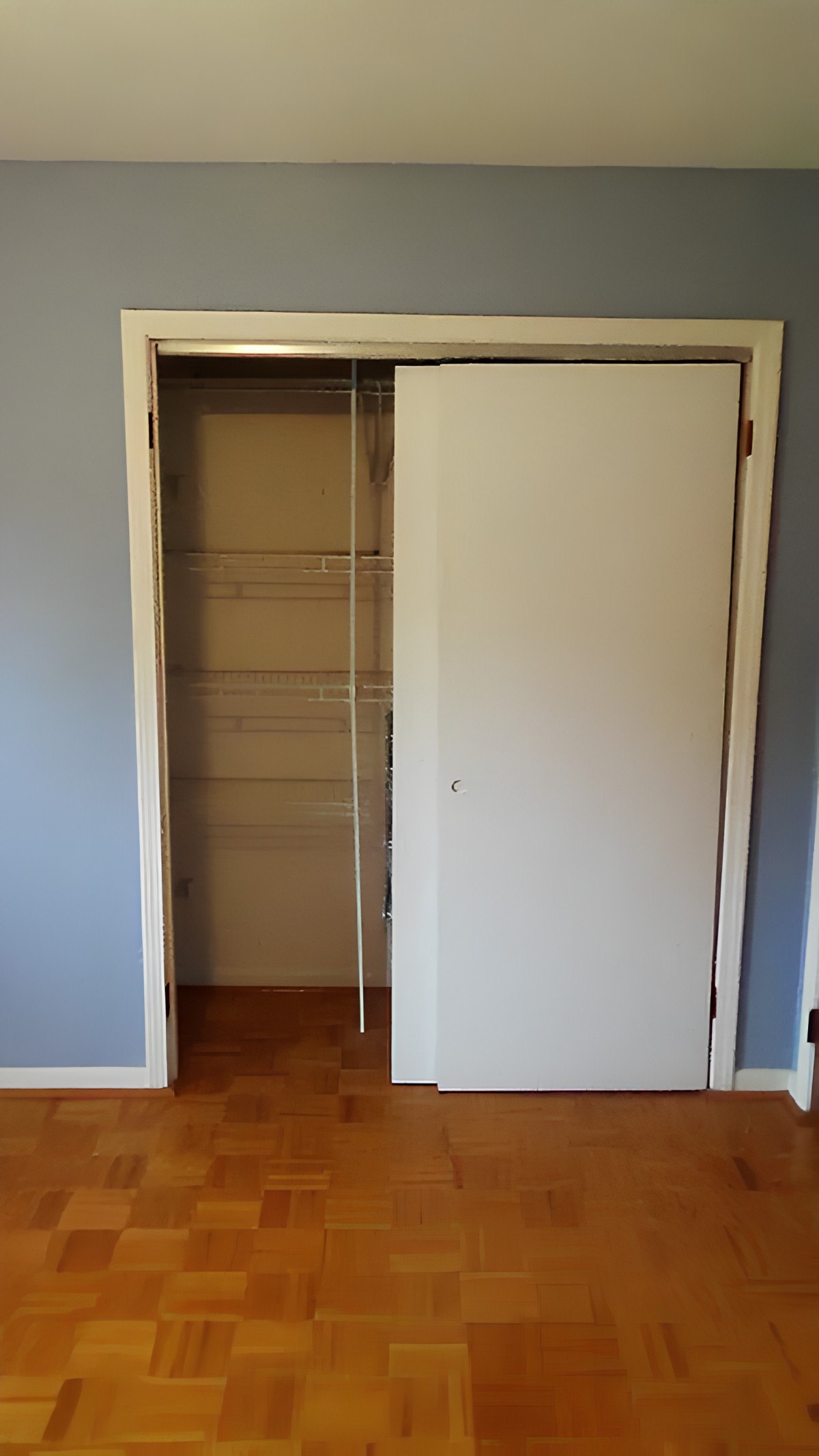 An empty closet with a sliding door in a home interior.