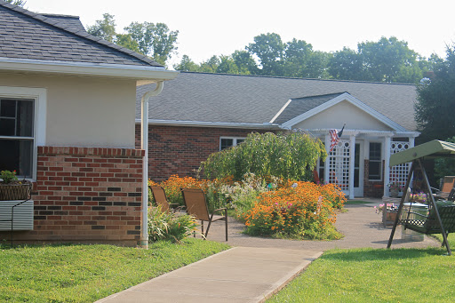 A serene residential building with a lush garden and pathway.