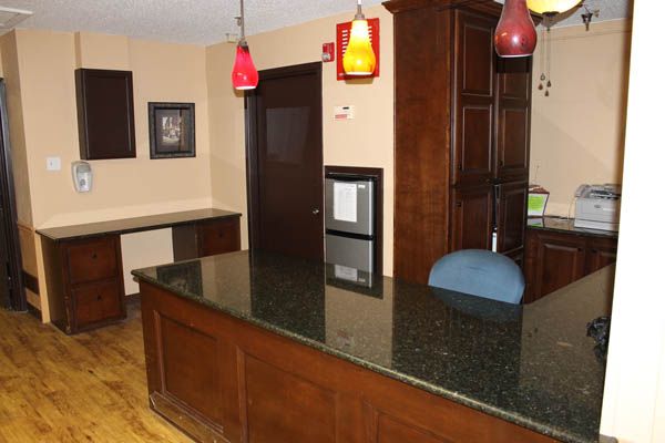 A reception desk with wooden finishes and colorful pendant lights in an office setting.