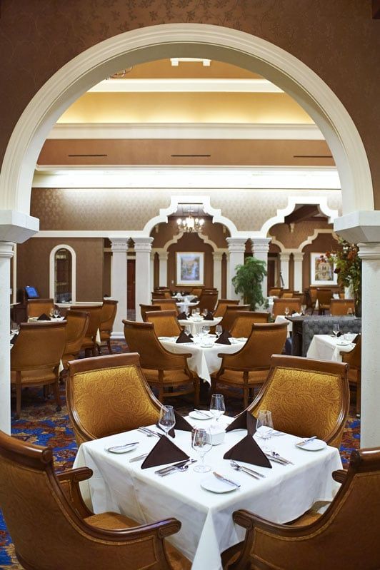 An elegant restaurant dining room with beautifully set tables and classic decor.