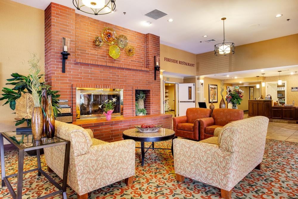 A cozy lobby with comfortable seating and a brick fireplace.