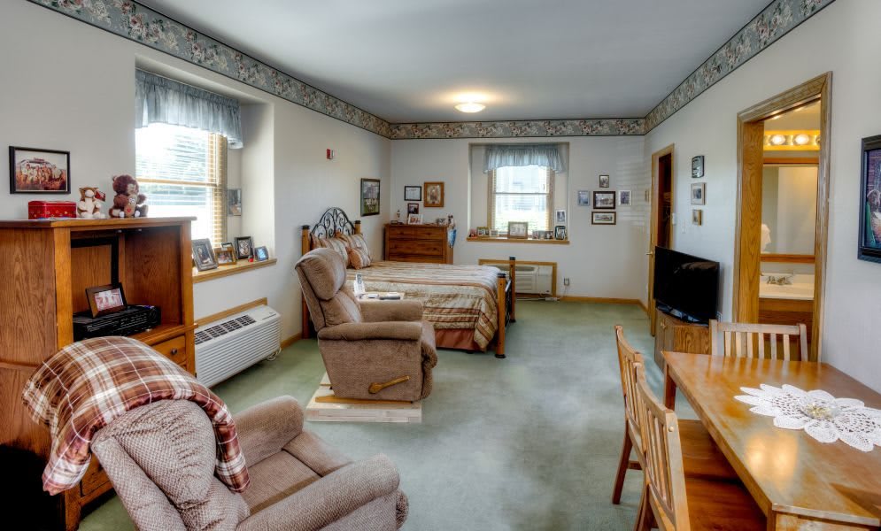 A comfortable living space with a mix of bedroom and living room furniture.