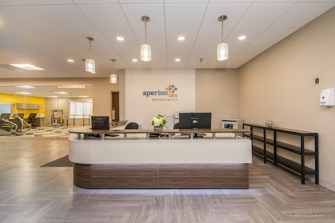 A modern office reception area with a front desk and computers.