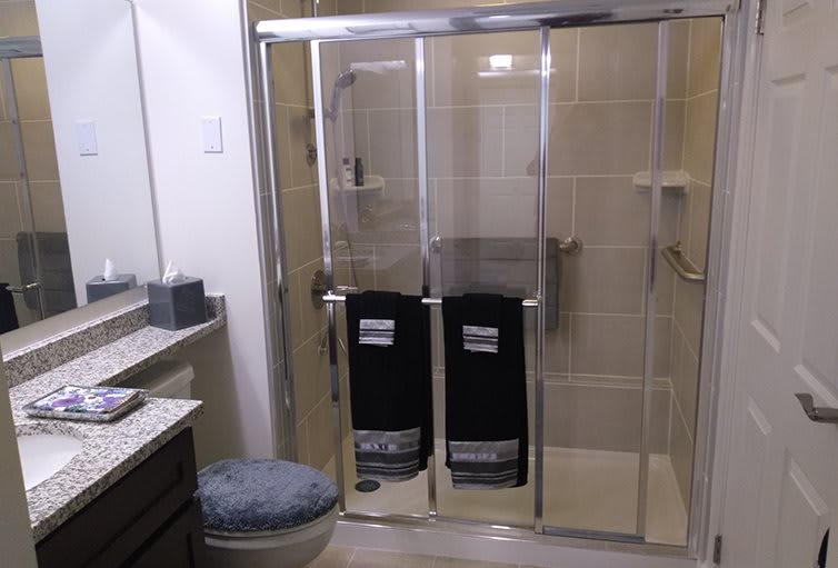 A modern bathroom with a glass shower enclosure and neatly arranged towels.