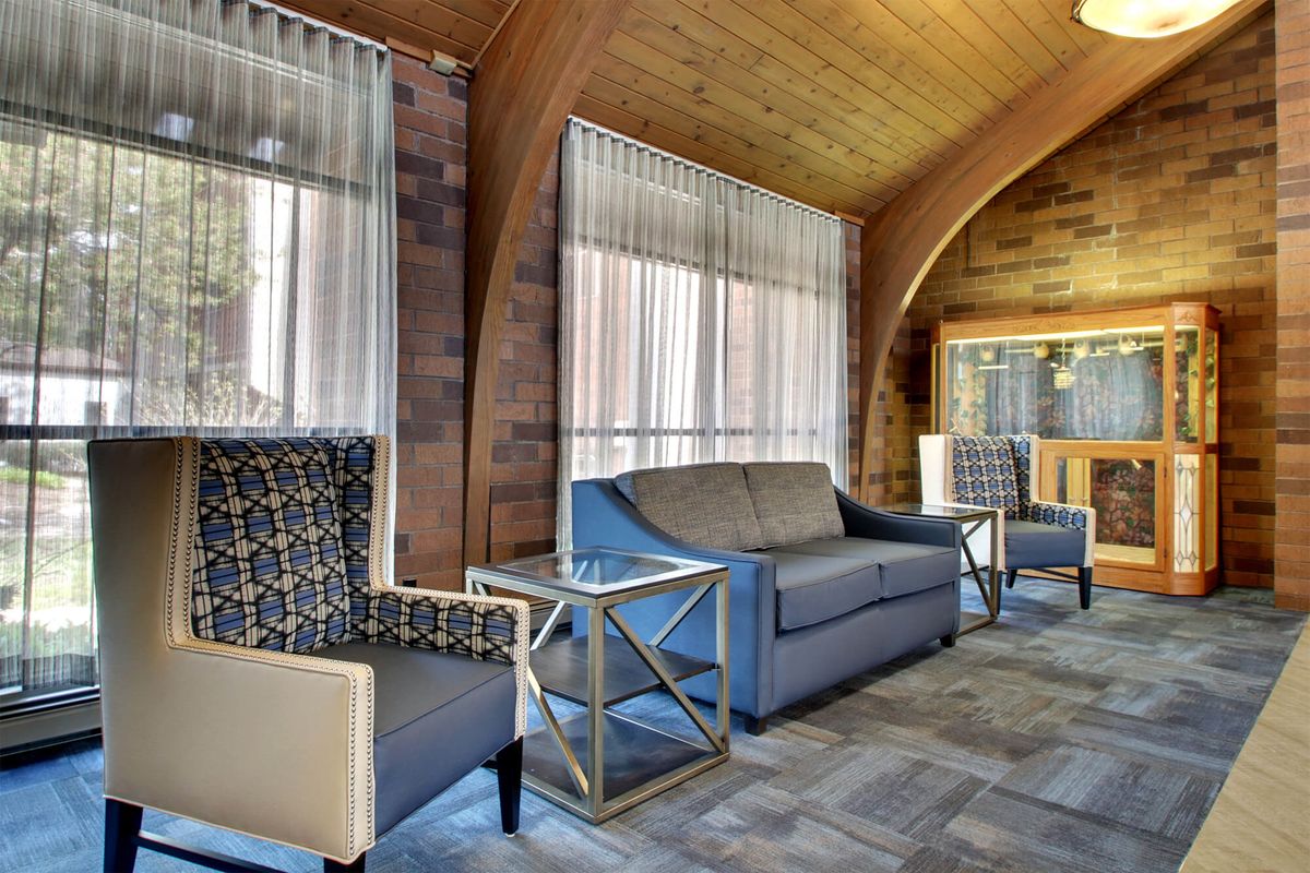 A cozy and modern living room with comfortable seating and a wooden ceiling.