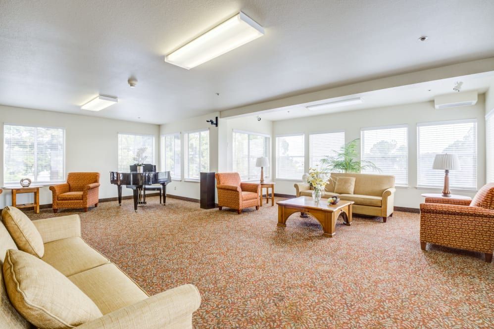 A spacious and well-lit living room with comfortable seating and large windows.