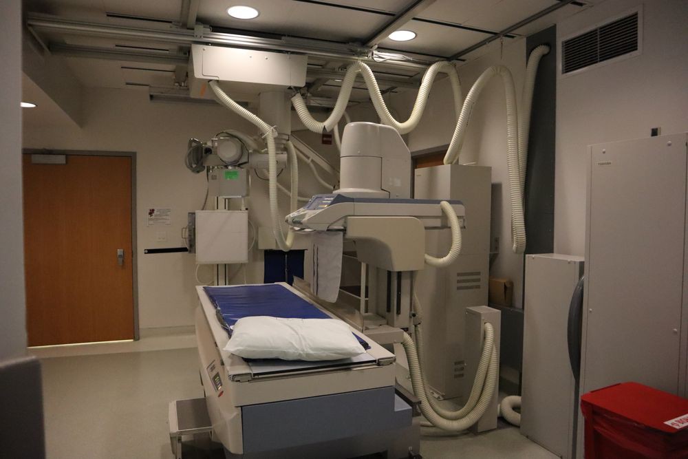 A hospital radiology room equipped with an x-ray machine.