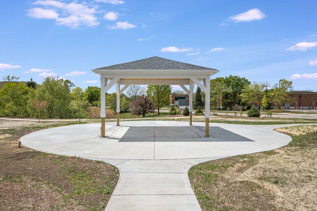 A gazebo in a park setting under a clear blue sky.