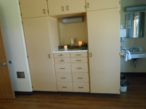 A wooden storage unit with cabinets and drawers in a hospital room.