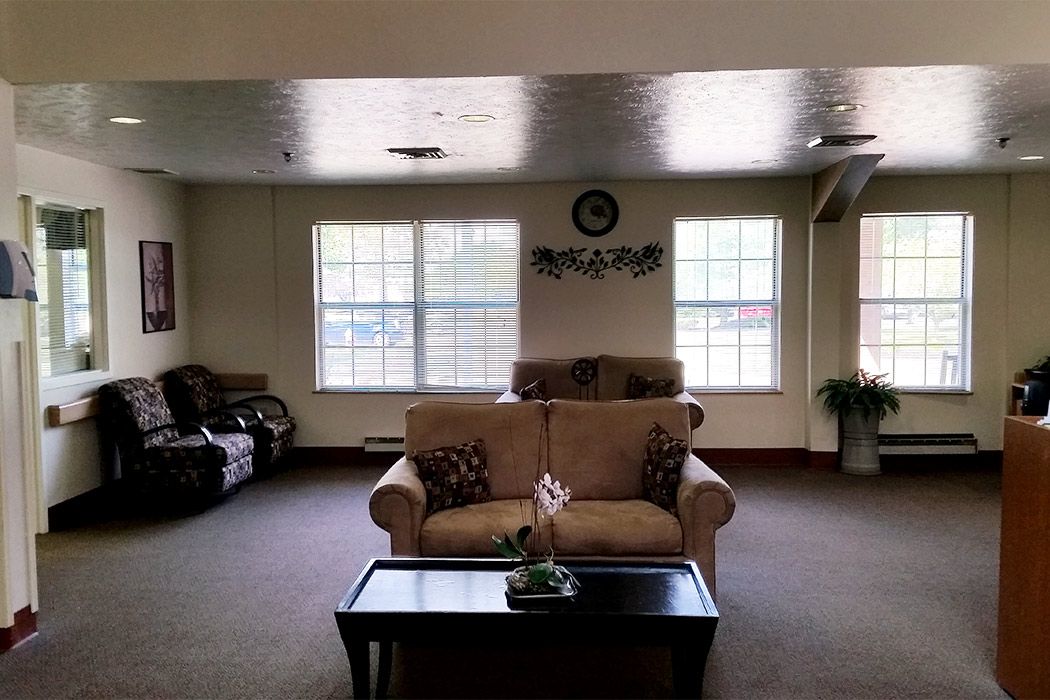 A cozy living room with sofas, a coffee table, and large windows.