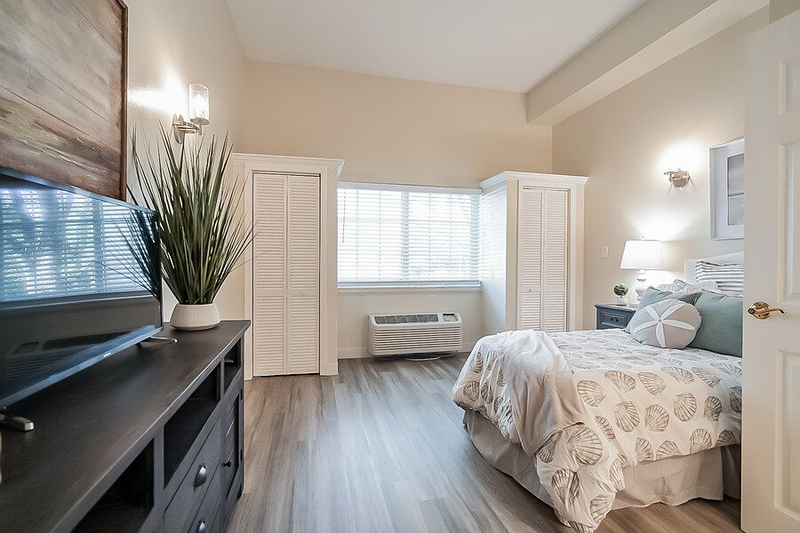 A modern bedroom with light walls, hardwood floors, and stylish furnishings.